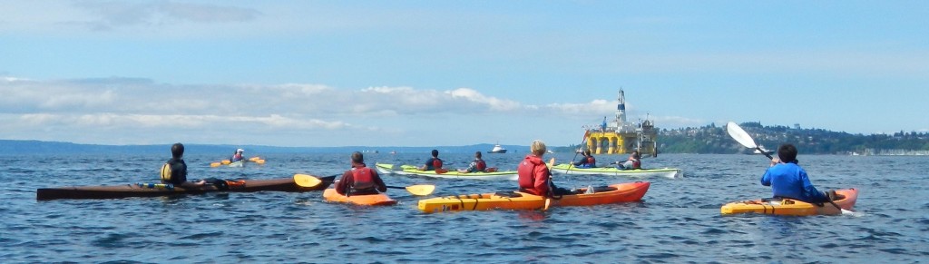 A dozen kayativists await the Polar Pioneer off Duwamish Head in Seatle.